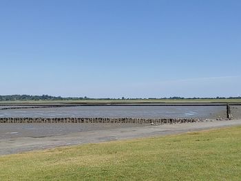 Scenic view of beach against clear blue sky