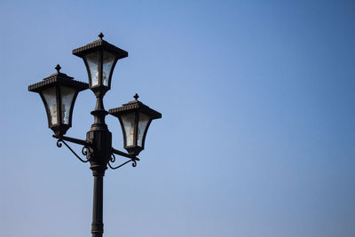 Low angle view of street light against clear blue sky