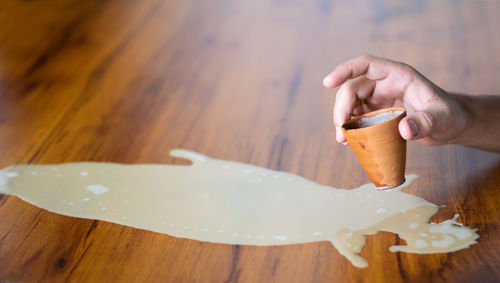 Close-up of hand holding ice cream on table