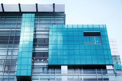Low angle view of modern building against blue sky