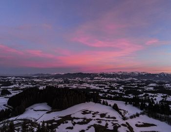 Scenic view of snow covered landscape against sky during sunset