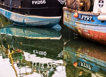 Graffiti on old boat moored at lake