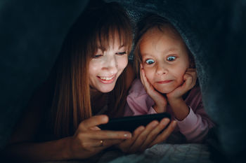 Mother and daughter watching video on smart phone