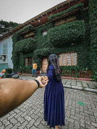 Rear view of woman standing against building