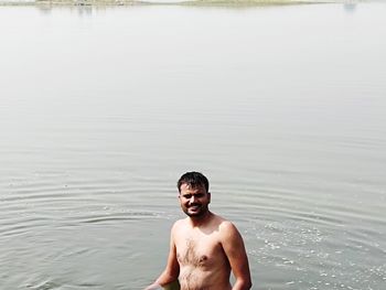 Full length of shirtless man standing in water