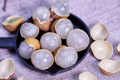 Closeup peeling ripe longan fruit on black plate