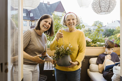 Portrait of smiling female friends standing by window