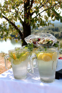 Glasses with a cold drink and lemon slices on a garden table  ready for an event 