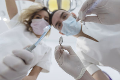 Low angle portrait of doctors wearing surgical mask at hospital