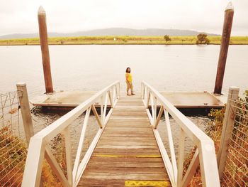 Woman standing on jetty by lake