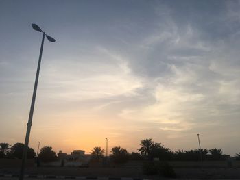 Silhouette street light against sky at sunset