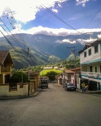 Houses by mountains against sky