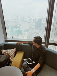 Man looking at camera while sitting in city