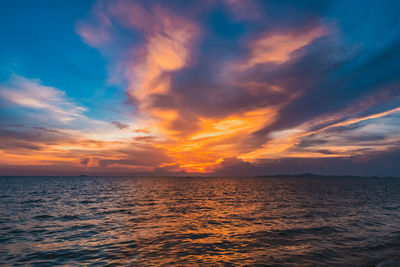 Scenic view of sea against dramatic sky during sunset