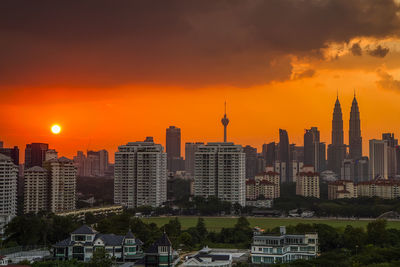 Silhouette of city against cloudy sky