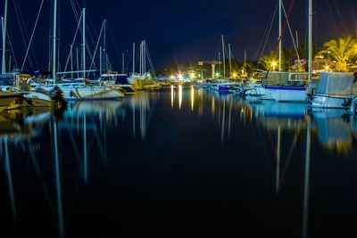 Boats in calm lake at night