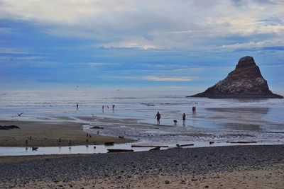 Scenic view of beach against cloudy sky