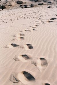 High angle view of footprints on sand at beach