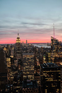 Modern buildings in city against sky during sunset