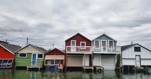 Houses by lake against sky