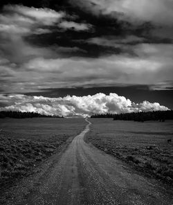 Empty road on field against sky