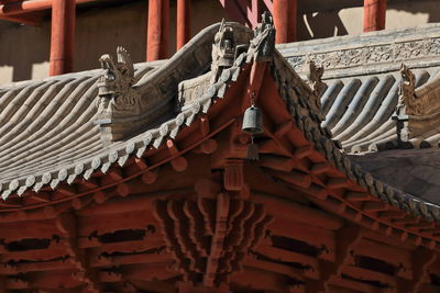 Low angle view of sculpture on roof of building