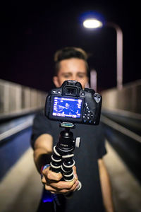 Man photographing illuminated camera