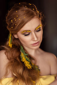 Portrait of a young woman in yellow mimosa flowers