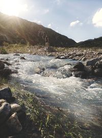 Scenic view of waterfall against sky