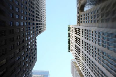 Directly below shot of skyscrapers against clear blue sky