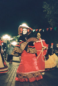 Portrait of smiling young woman dancing at night