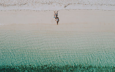 Drone view of couple at beach on sunny day