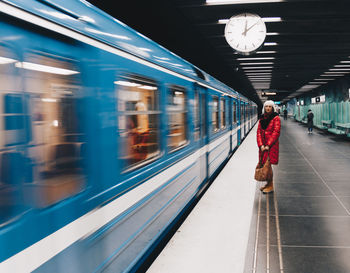 Woman standing by train at railroad station platform