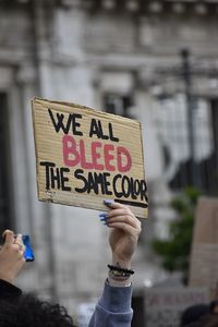 Low section of person holding a cartel against racism