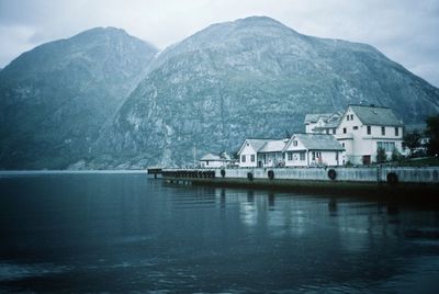 Houses by lake against mountains