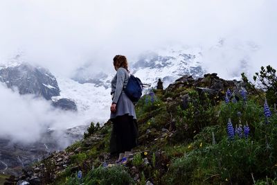 Woman standing on rock against sky