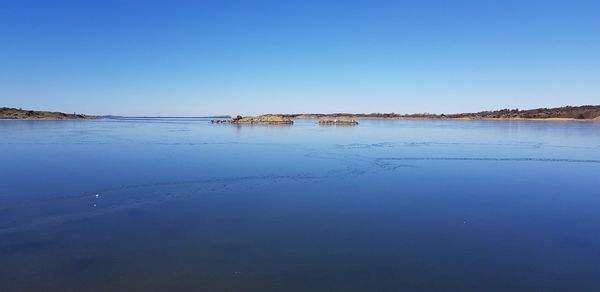 Scenic view of sea against clear blue sky