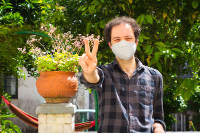 Full length of man wearing sunglasses standing against plants in yard