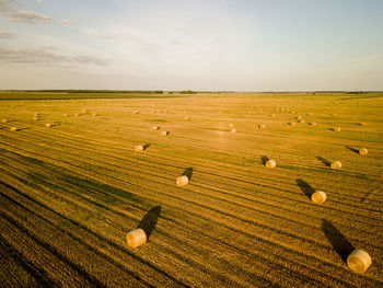 Hay bales on field against sky
