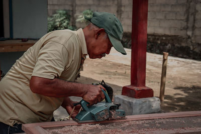 Side view of man working at workshop