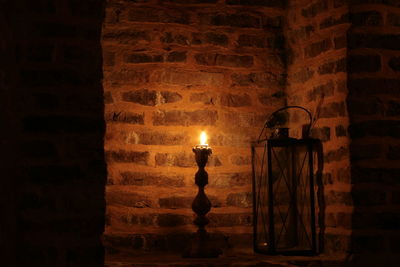 Close-up of lit candle in darkroom