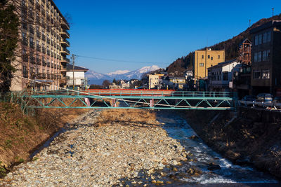 Bridge over river against buildings in city