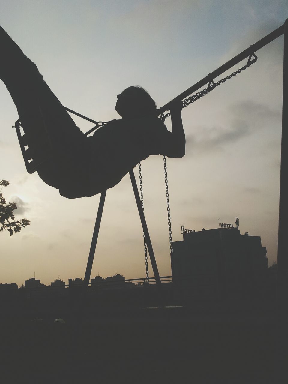 low angle view, sky, built structure, architecture, silhouette, building exterior, amusement park, arts culture and entertainment, sculpture, amusement park ride, outdoors, dusk, sunset, crane - construction machinery, statue, cloud - sky, mid-air, travel, art and craft, day