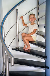 Low angle view of young woman sitting on escalator