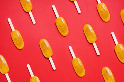 Top view passion fruit popsicle or ice lolly or ice pops flat lay pattern on red colored background