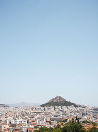 Buildings in city against clear blue sky