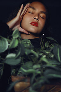 Teenage girl with eyes closed and plants at home