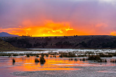 Scenic view of landscape against orange sky