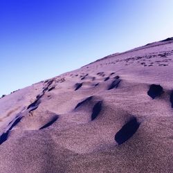 Sand dunes in desert against clear sky