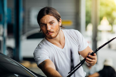 Portrait of young man holding car